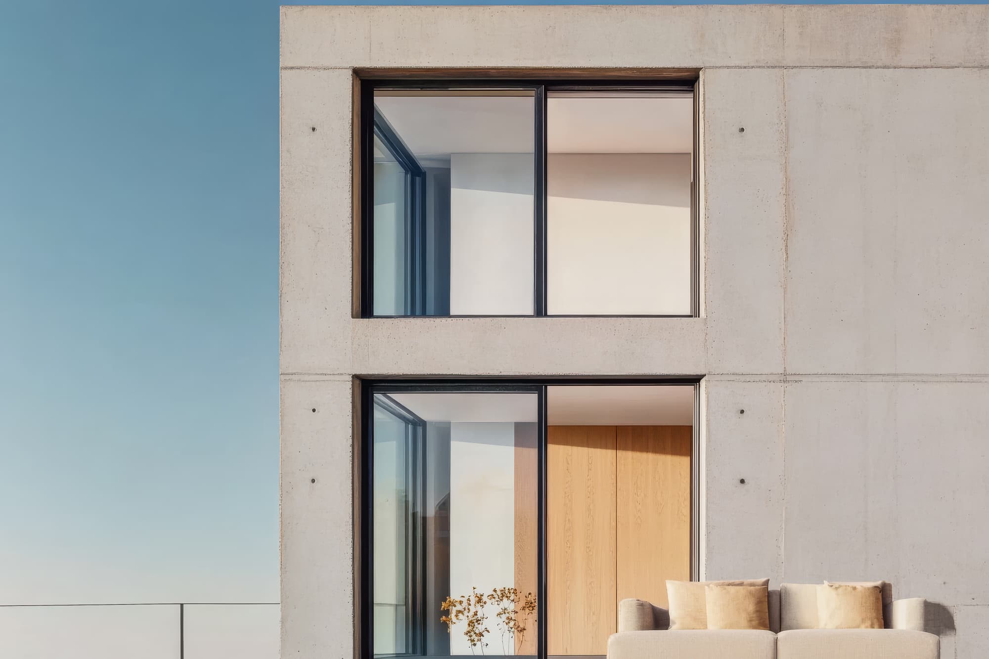 Minimalist building with floor-to-ceiling glass windows and concrete facade